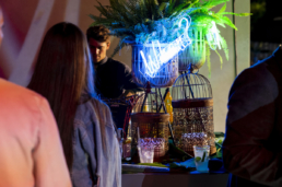 Dettaglio dell’insegna luminosa blu tra le piante al Gala Dinner Ariostea 2019