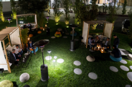 Area lounge verde con sedute circolari e tavolini luminosi per Ariostea Gala Dinner 2019
