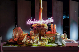 Buffet con verdure e insegna luminosa nell’allestimento Ariostea Gala Dinner 2019
