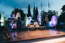 Palco esterno con illuminazione viola e alberi sullo sfondo al Gala Dinner Iris Ceramica 2017