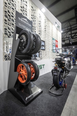 Espositore Vredestein con cerchi arancioni accanto a una moto nello stand EICMA 2019